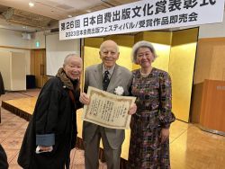 Hans holds the certificate of commendation 1