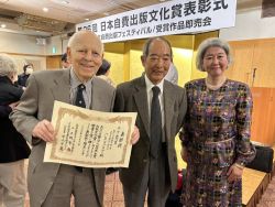Hans holds the certificate of commendation 2